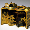 Black lacquered tobacco tray in the shape of a folding screen, with handle and natural landscape in maki-e