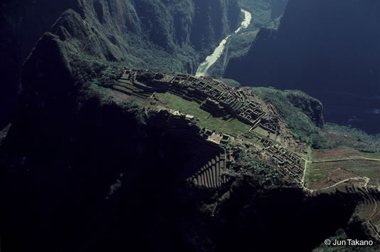 空から見た無人のマチュピチュの都市遺跡と山麓を流れるビルカノタ川