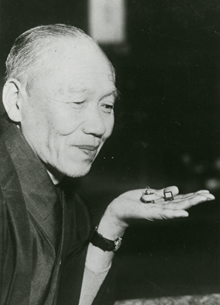 手のひらにミニチュアを載せる中田實。昭和12年。