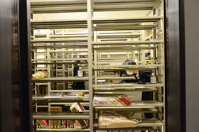 書庫の図書を箱詰め、運び出しするスタッフ。